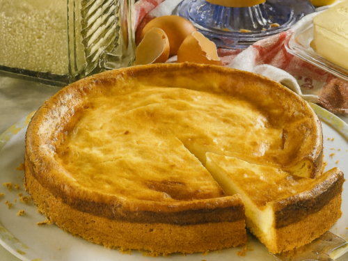 Old-Fashioned German Cheesecake (Altdeutscher Käsekuchen) – a golden, creamy baked cheesecake in a springform tin with a slice cut out, showing its soft quark filling and rich buttery crust.